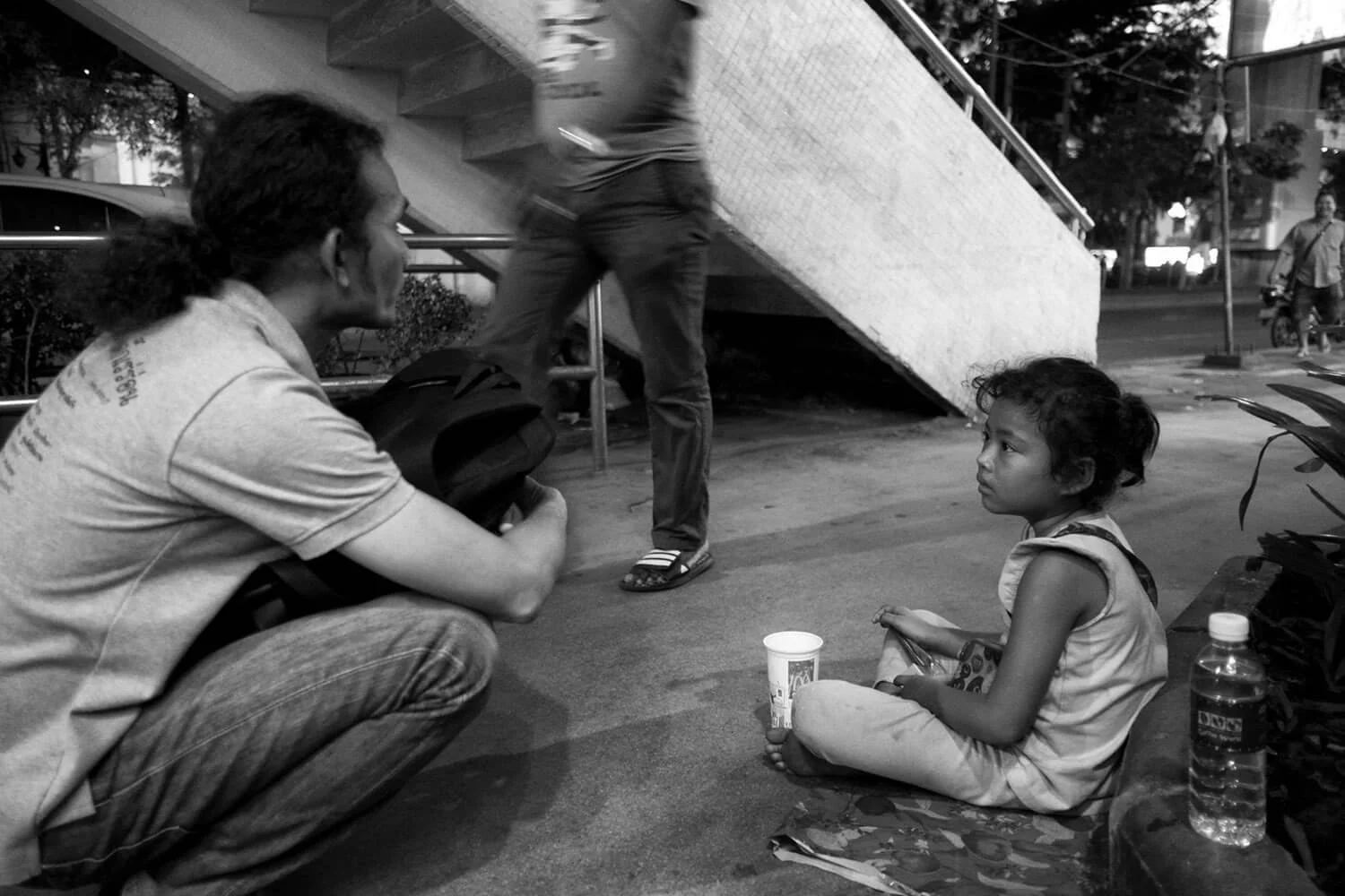 HDF worker chats with a Cambodian girl begging on the street in Bangkok.