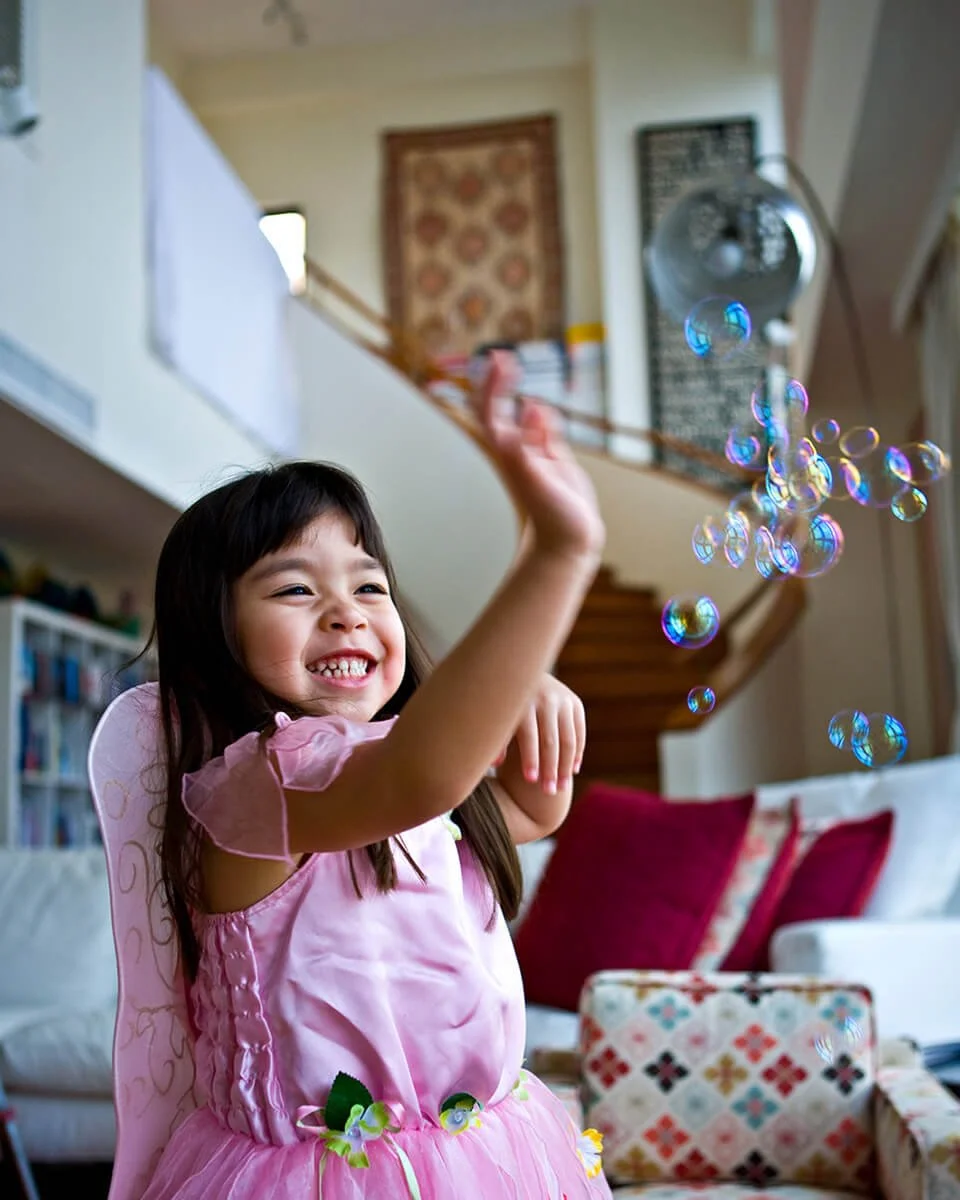 Girl plays with bubbles at home in Central, Hong Kong
