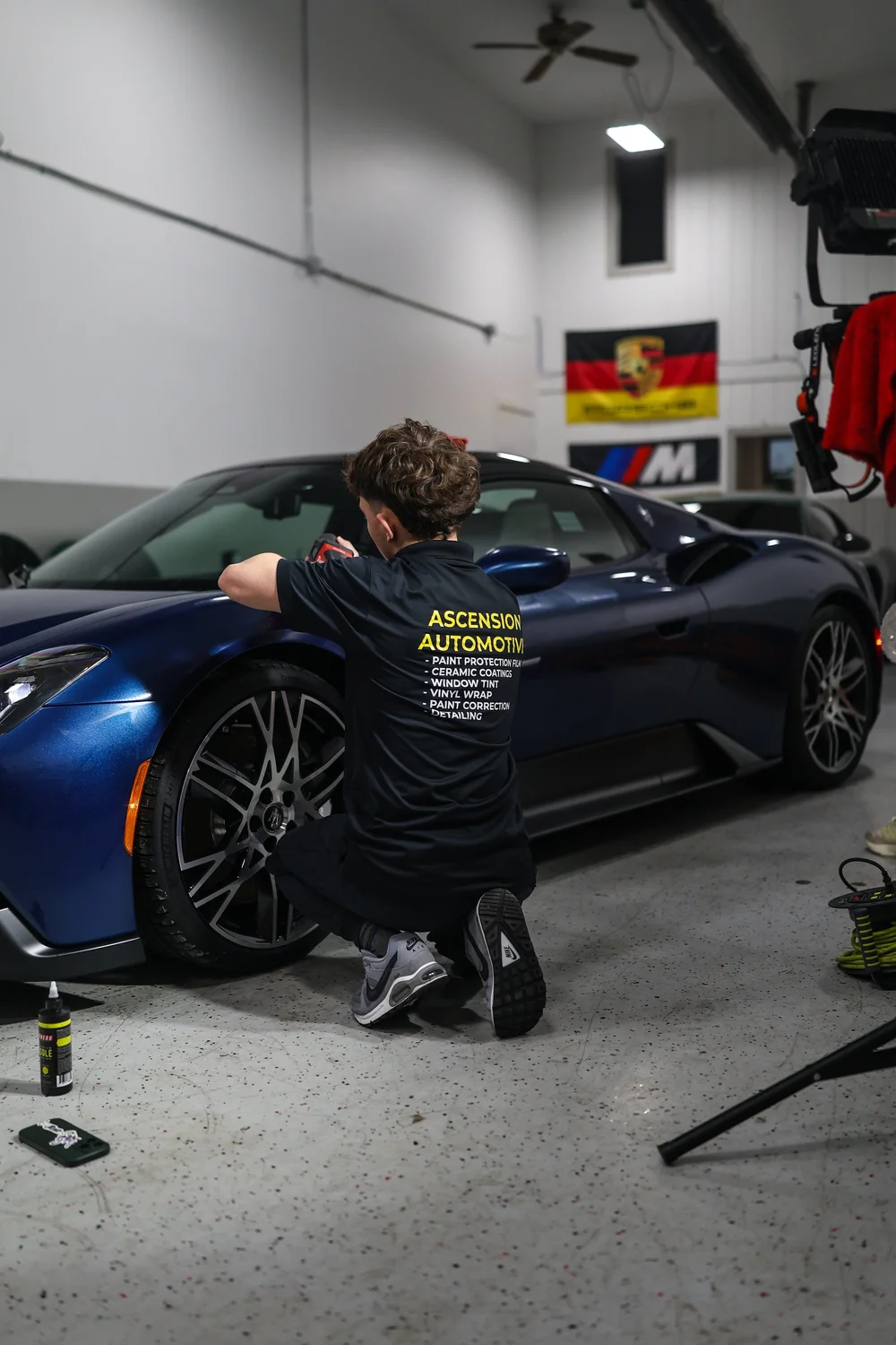 Ascension technician working on a blue Ford GT inside the climate-controlled studio