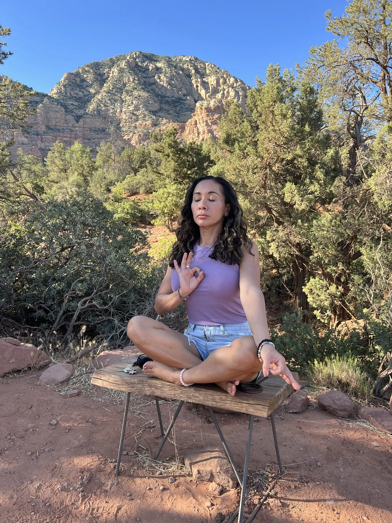 Stephanie seated in meditation beneath a mountain