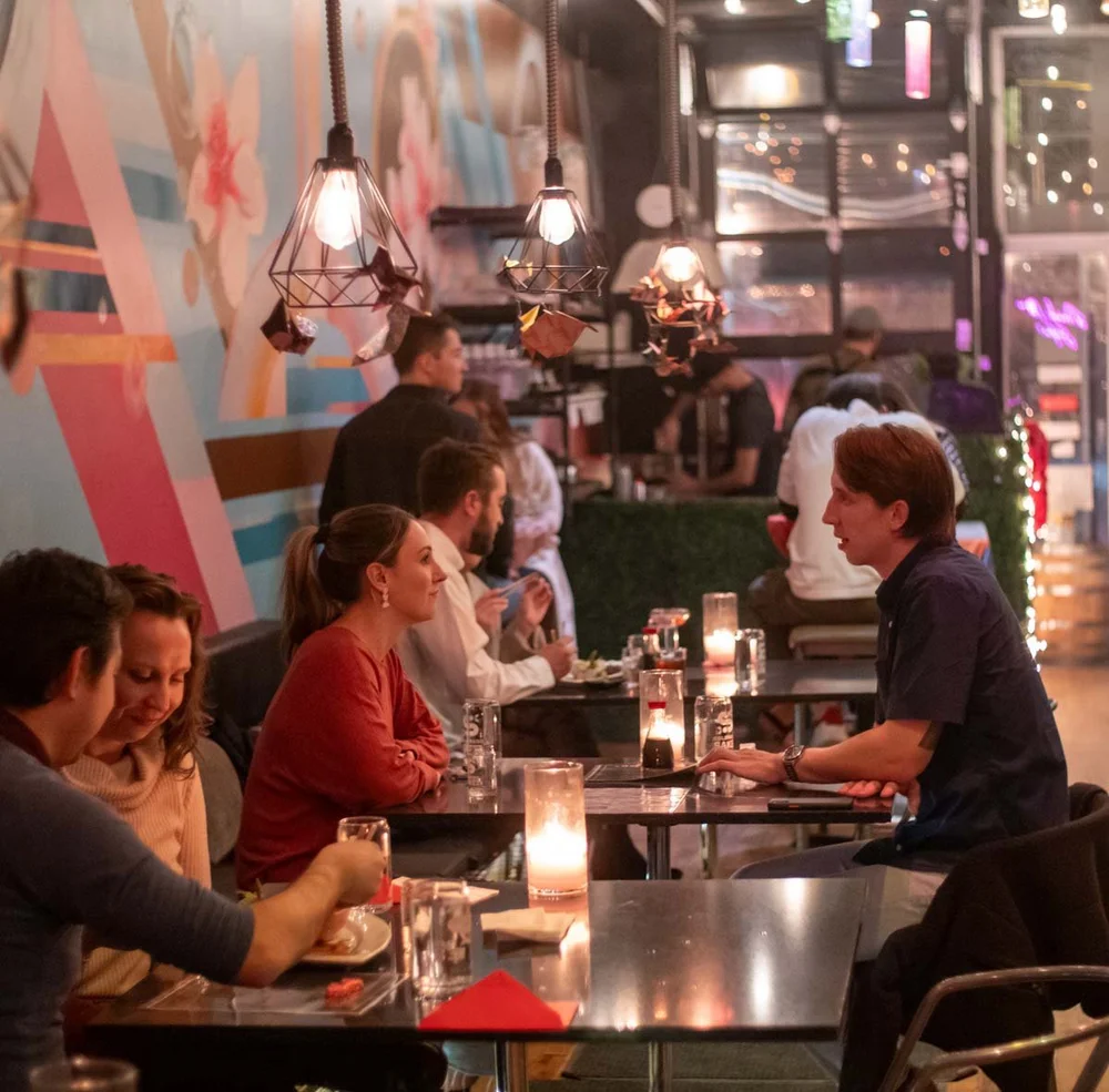 Friends sharing food and sake at the Colorado Sake Co. taproom