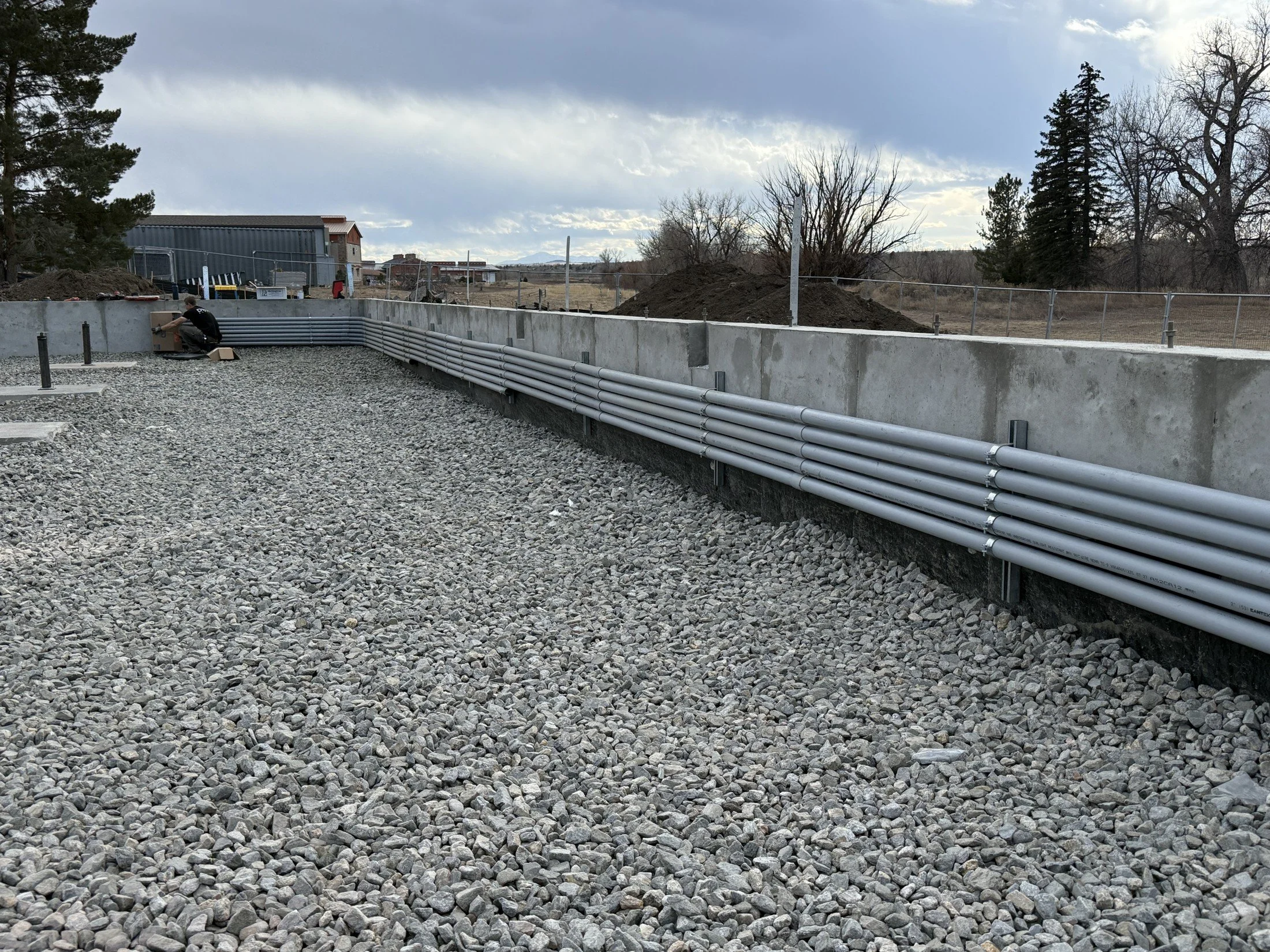 DNVR electrical conduit installation along a building foundation
