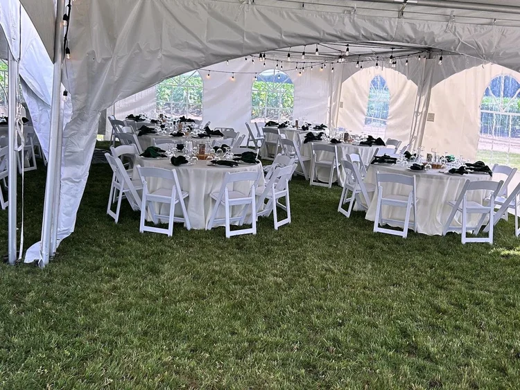 Round tables set for dinner inside a marquee tent