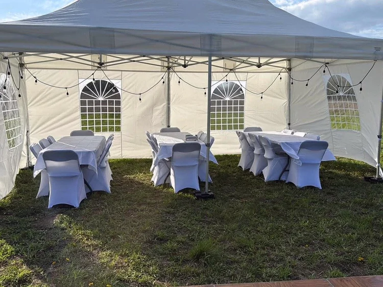 White chair covers and tablecloths inside a tent