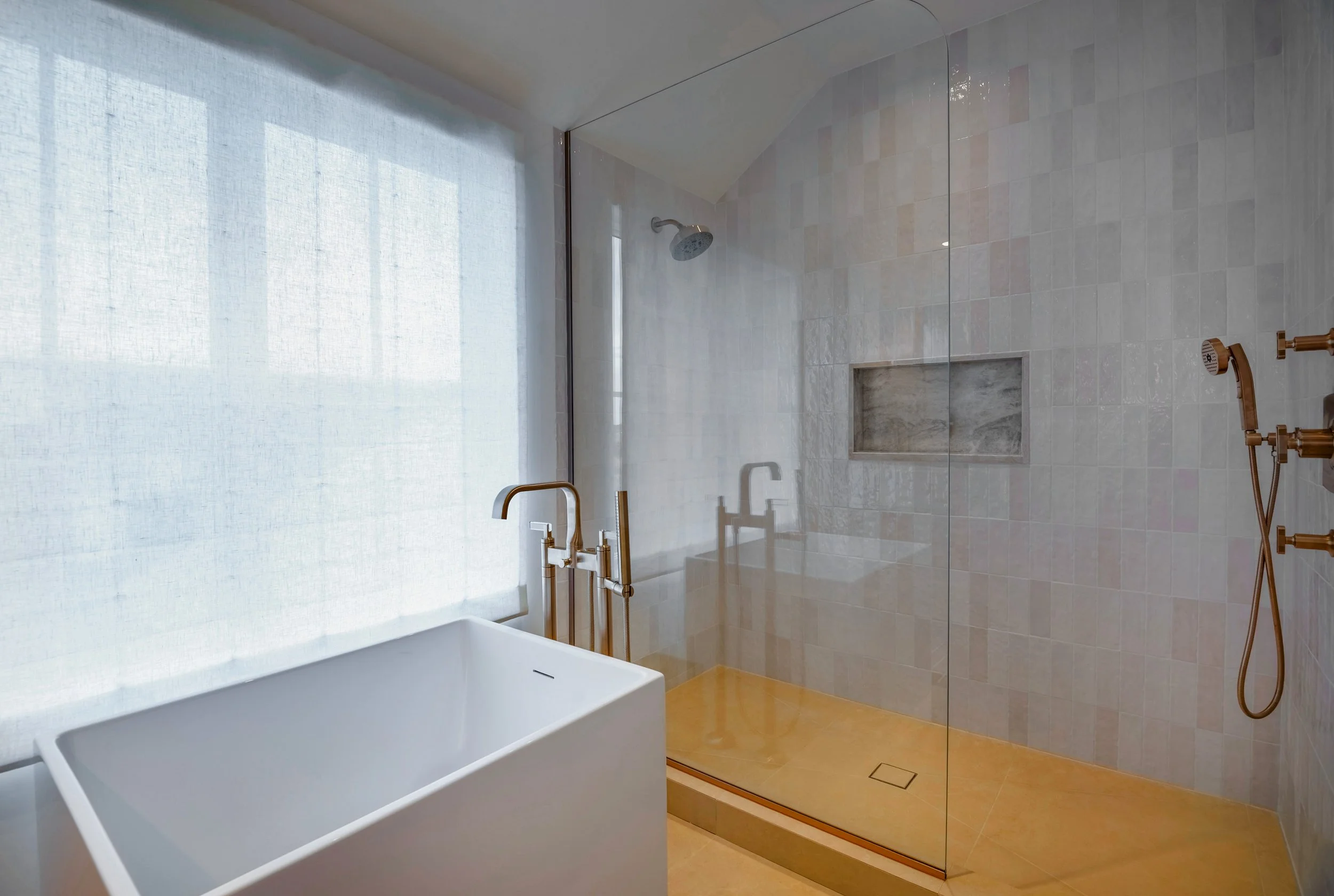 Large primary bathroom with a freestanding tub beside a glass-enclosed tiled shower in a Hamptons gut renovation