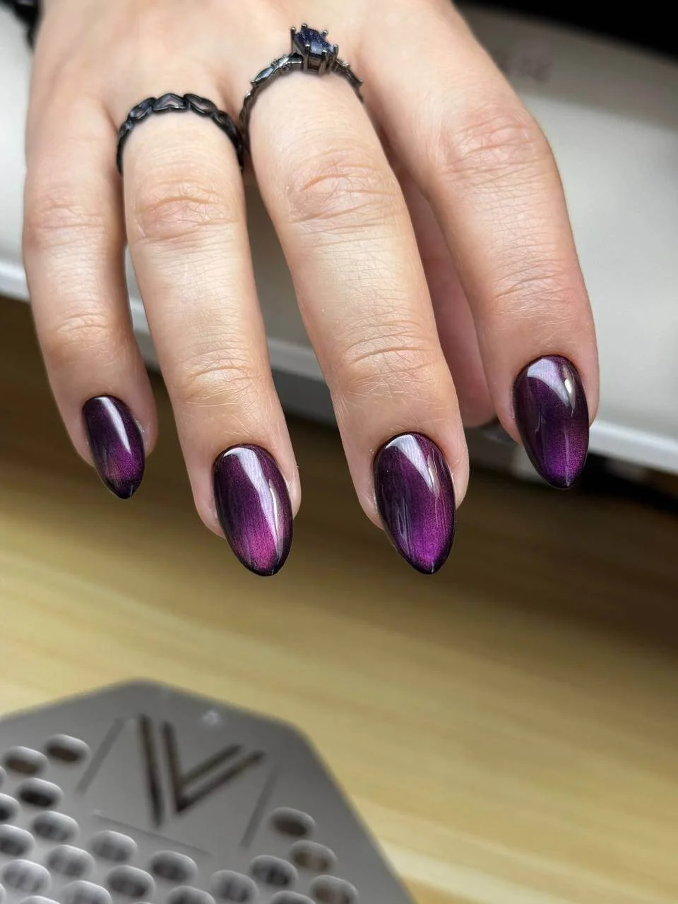 Shortened sharp almond nails with reflective purple cat eye gel finish at Mars Nails