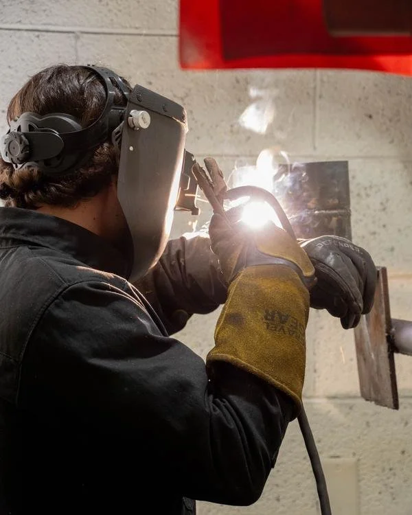 A tnAchieves student welding in a technical training lab