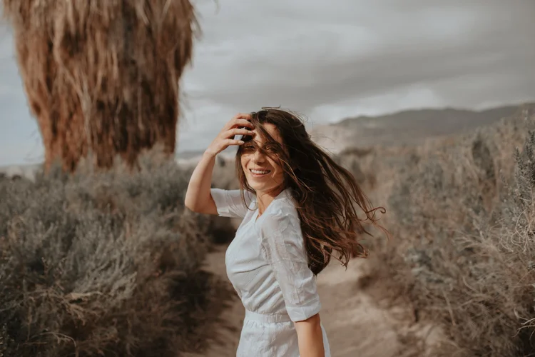Woman in a white dress in the desert wind