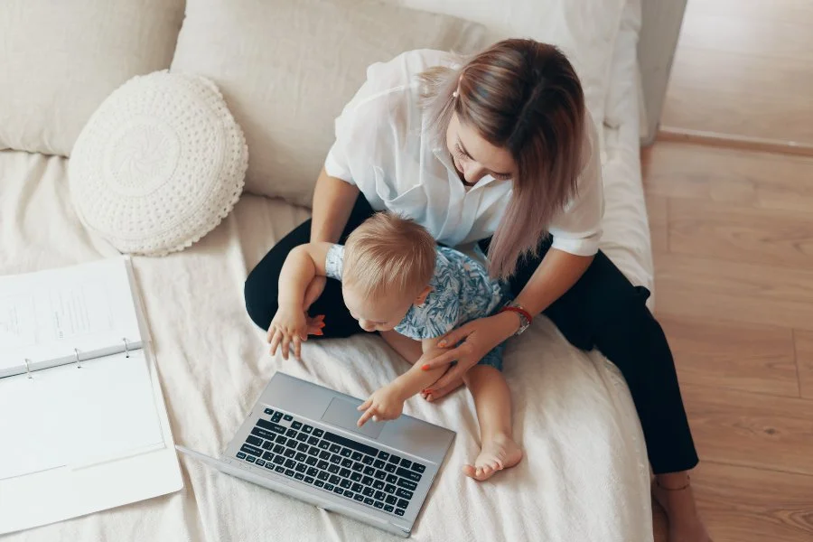 Mother working on couch with child