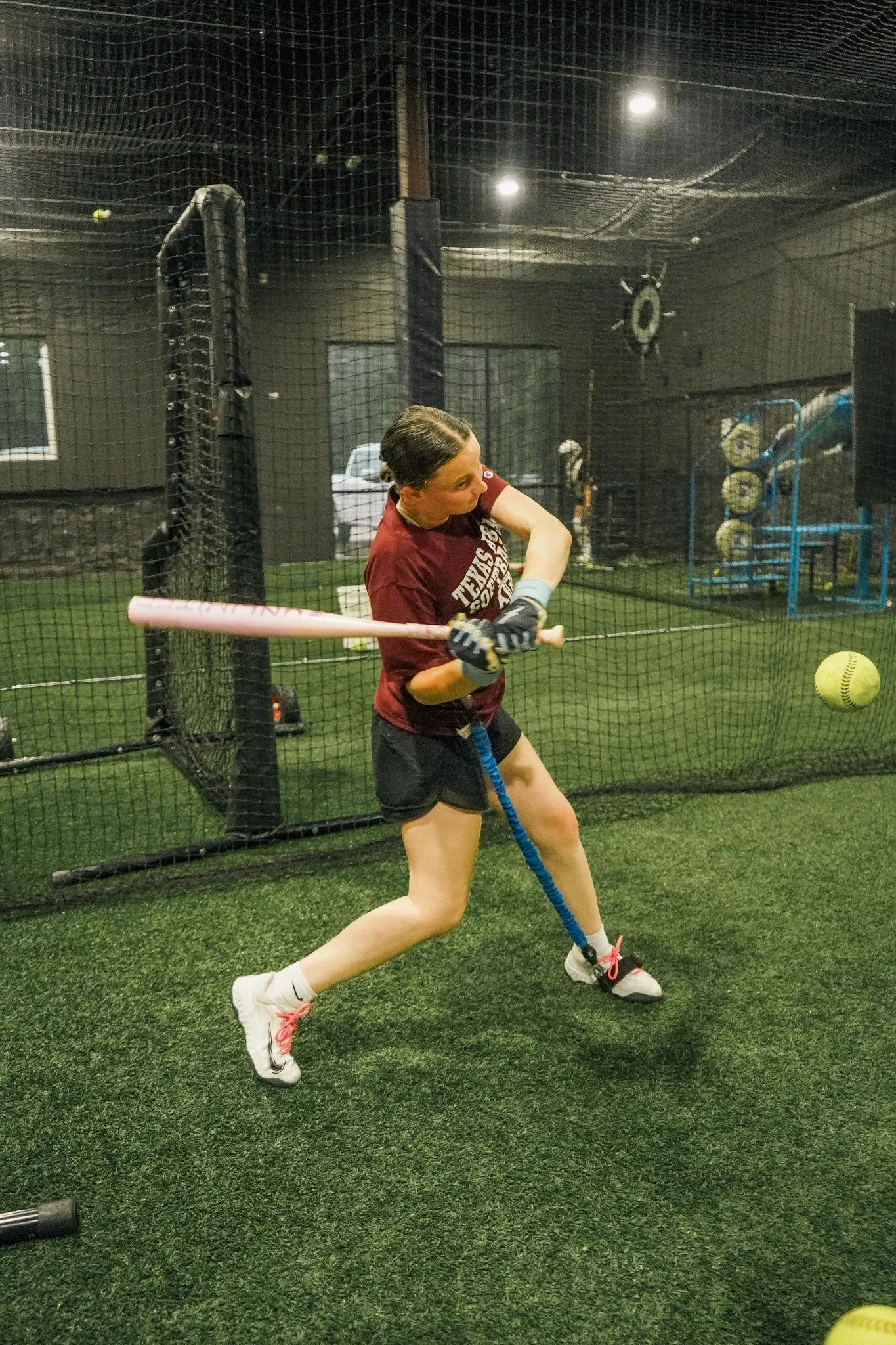 Softball athlete taking a swing inside a Lone Star Sports Zone cage