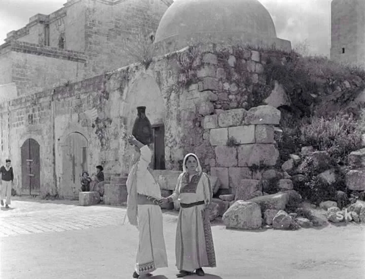 A photo of women carrying water from the Al-Zaybaq well in the city of Lydd, 1935