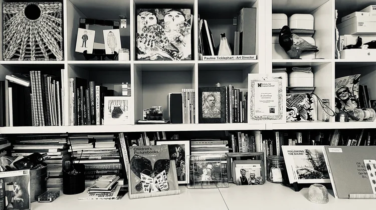 Book shelves and cubbies containing decades of memories, references, books and tools of the trade.