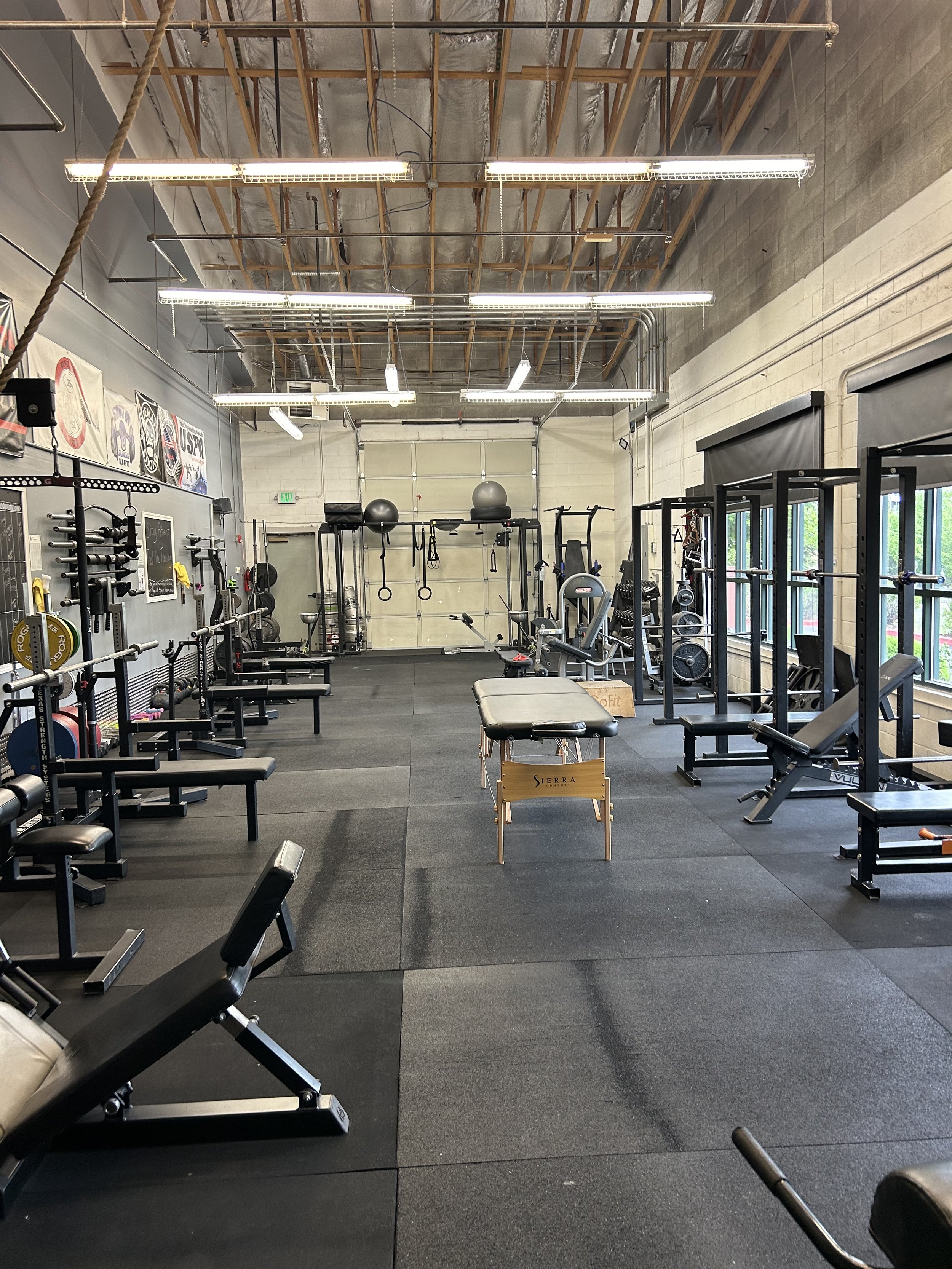 Dobson Strength training floor with squat racks, benches, and barbells