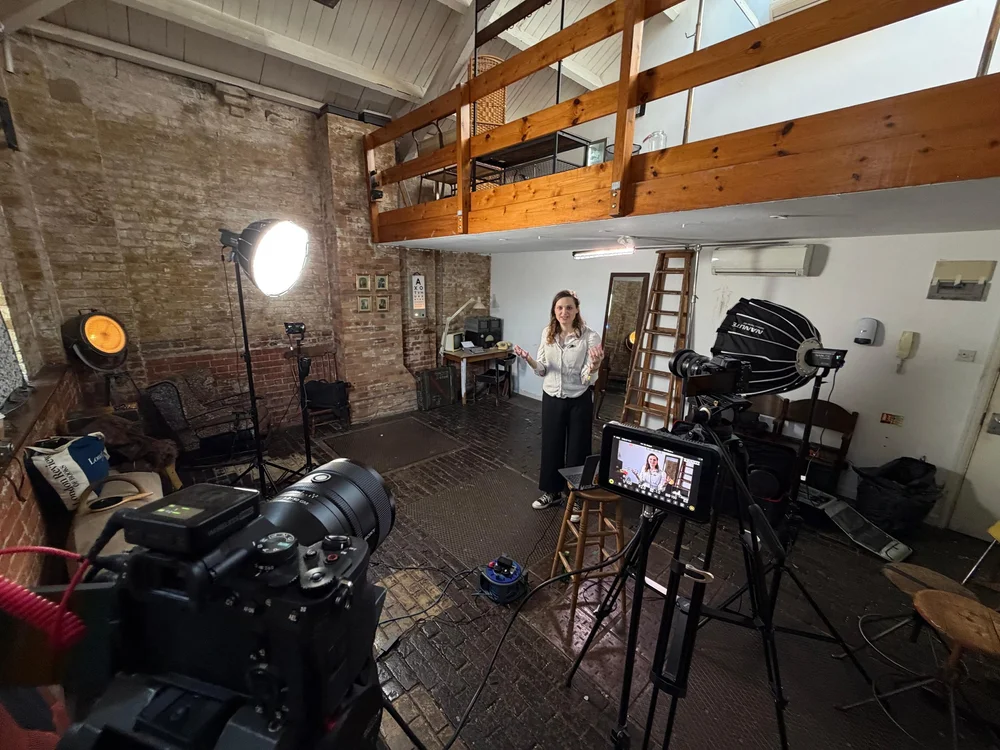 Jocelyn Burnham presenting to camera in a London studio during an Access Learning filming day, with lights and cameras in the foreground, 2025