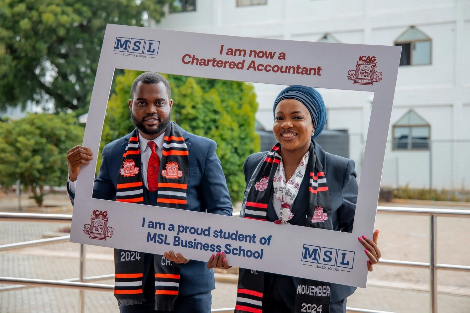 Two MSL graduates celebrating their Chartered Accountant achievement with an MSL branded frame