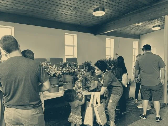 Families and volunteers around a table at a church event