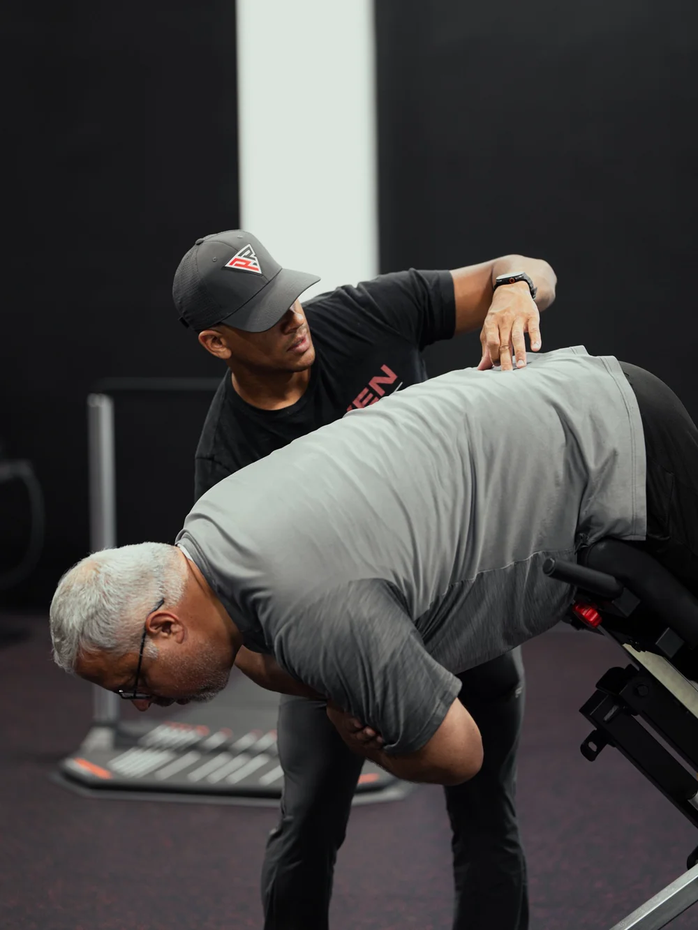 Clinician guiding a patient through a hip hinge