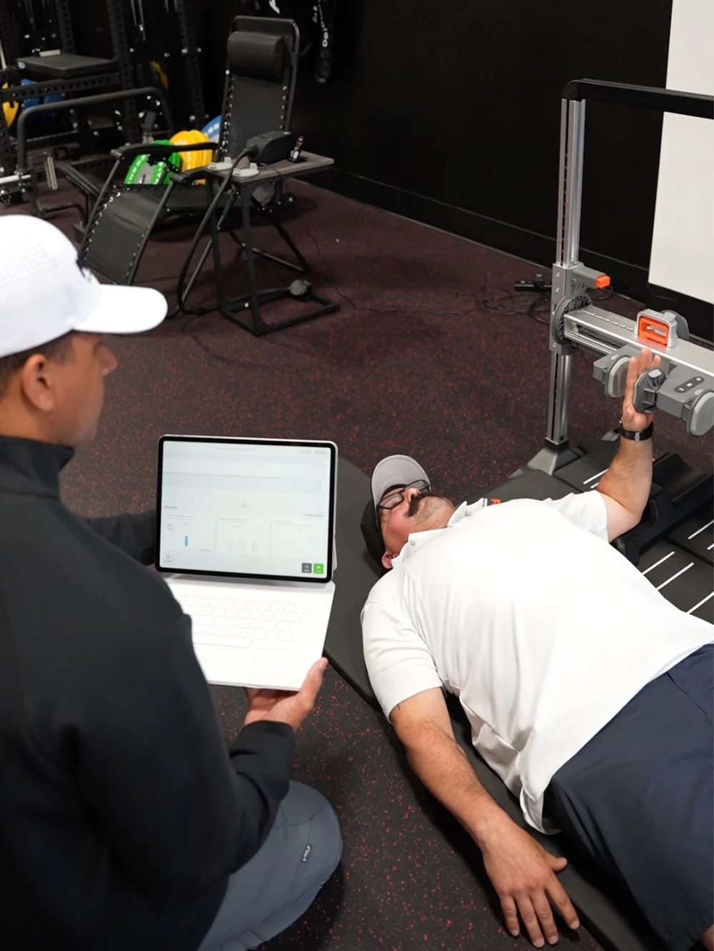 Proven clinician reviewing ForceFrame shoulder strength data on a tablet during testing