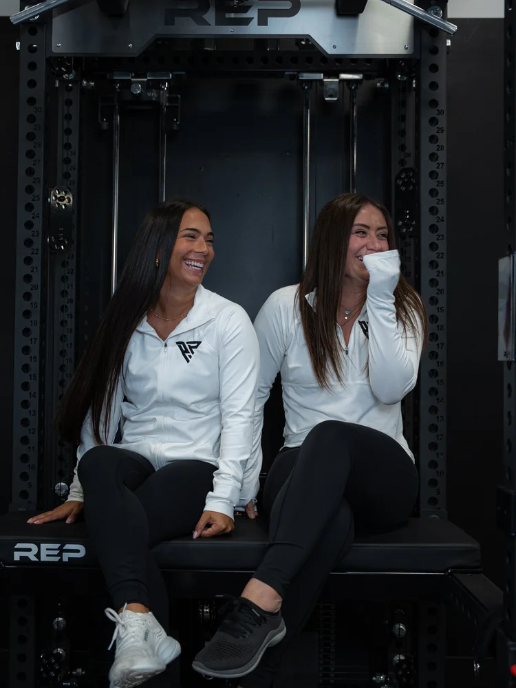 Two Proven Performance team members laughing together in the gym
