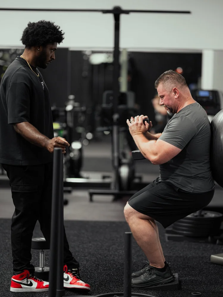 Clinician coaching a patient through a supported split squat during post-surgery rehab