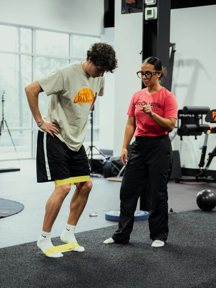 Clinician coaching an athlete through a banded movement drill