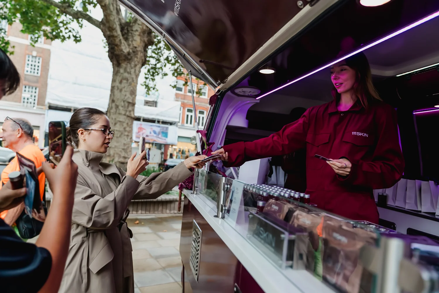 Guest receiving a printed card at the 111SKIN Repair Van serving hatch