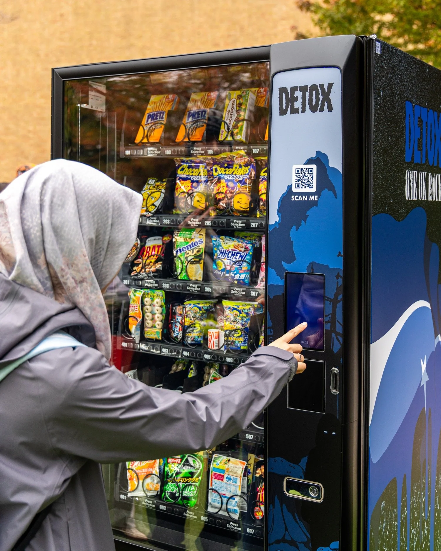 Guest selecting a Japanese treat from the ONE OK ROCK DETOX vending machine