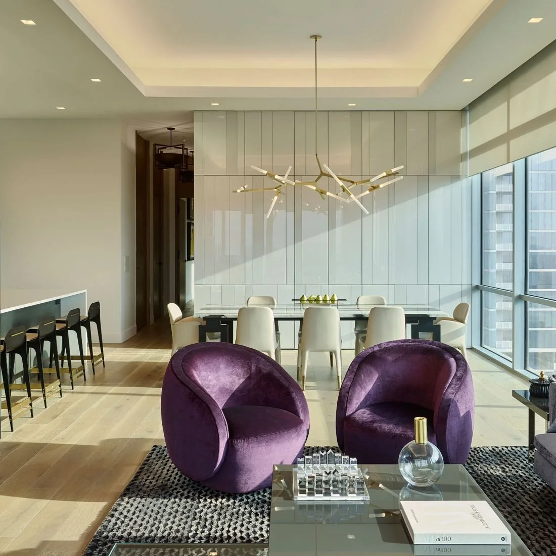 Open dining and living room with a high ceiling and large windows