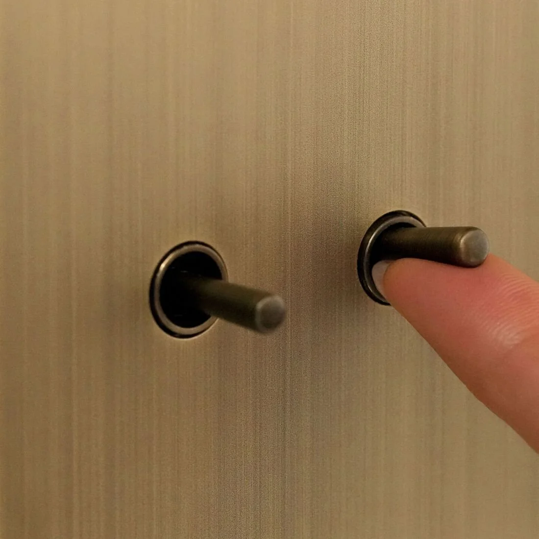 Finger pressing an Aviena brass toggle