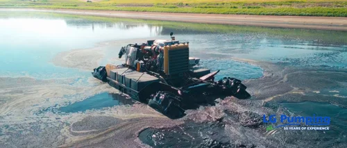 Floating agitation equipment mixing a manure lagoon, with circular currents visible around the machine.