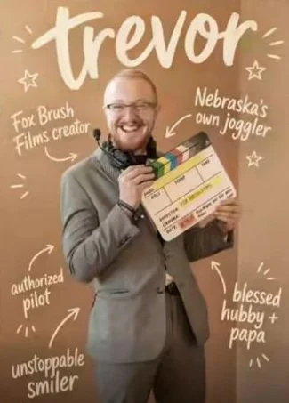 Trevor McQuay holding a film slate, with handwritten notes about his interests.