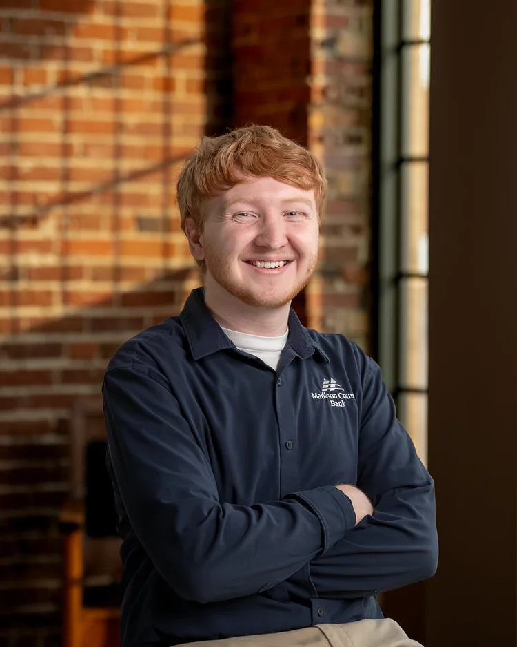 Trey standing with his arms folded for a business portrait
