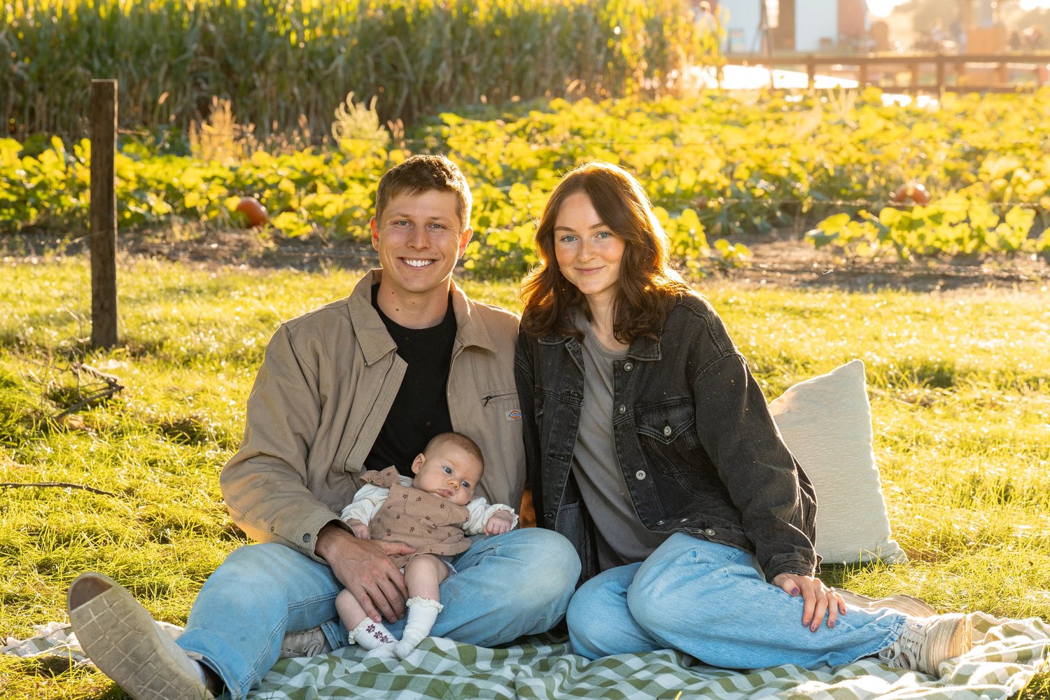 Parents sitting with their baby on a blanket during a fall family photo session in Norfolk, Nebraska.