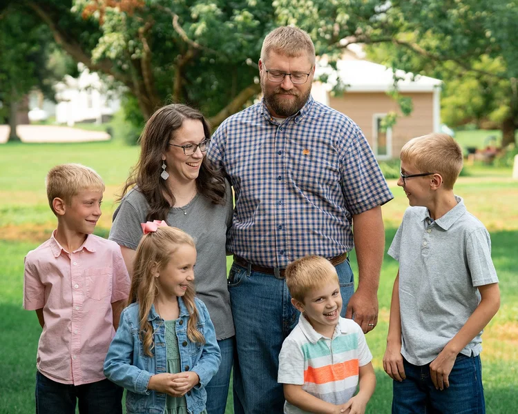 The Jensen family sharing a laugh between posed photographs.