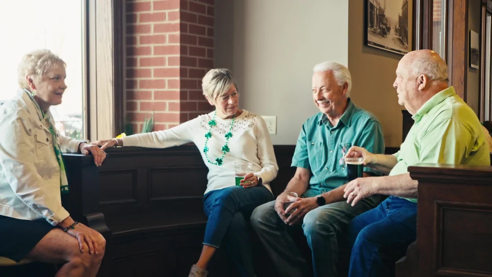 Guests sharing a conversation at Commercial State Bank's centennial celebration in Elkhorn, Nebraska