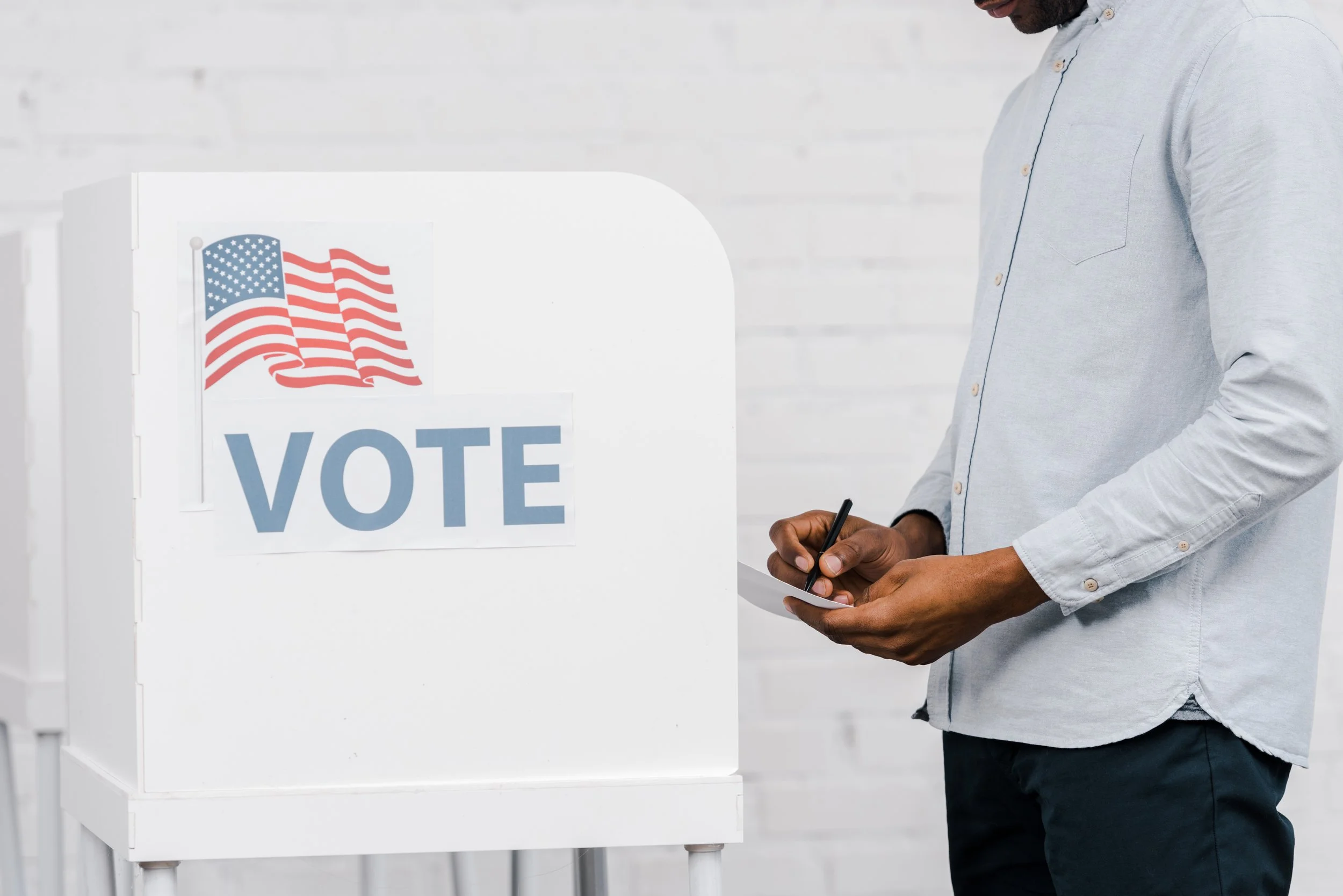 Person filling out a ballot at a voting booth
