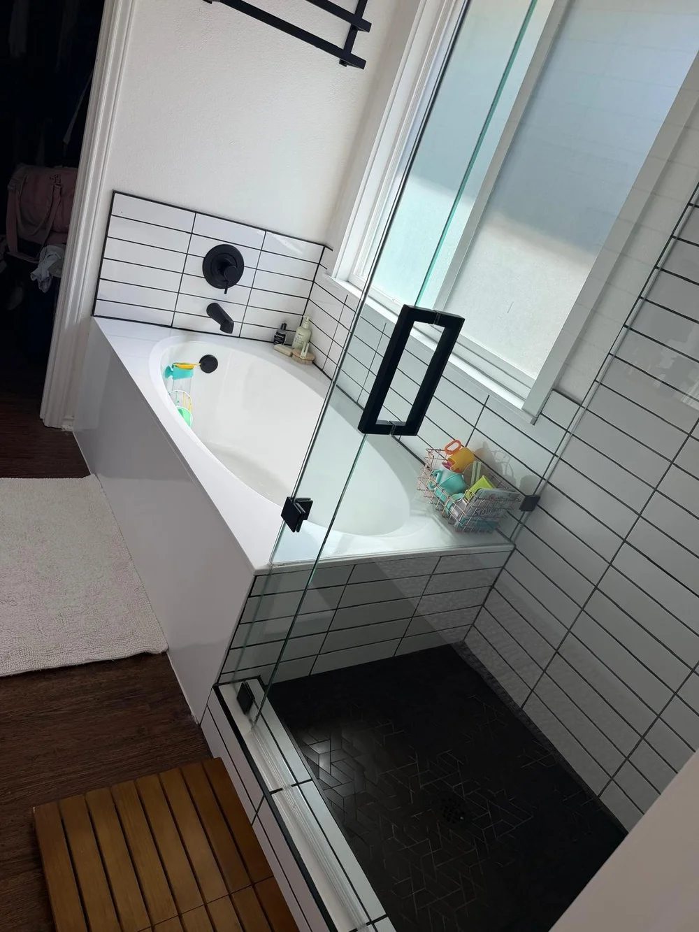 After: clear glass shower door and clean soaking tub in an Austin bathroom cleaned by Sparkly Maid Austin