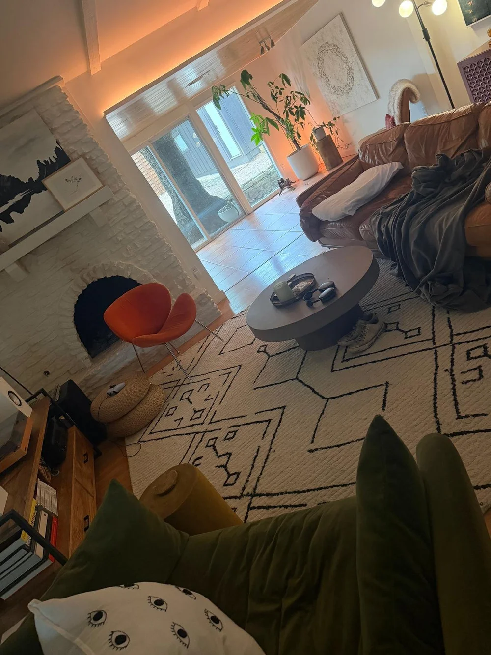 Before: living room sectional piled with throws and bags in an Austin home