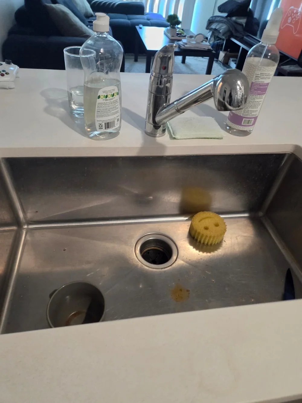 Before: kitchen sink with food residue and a used sponge in an Austin home