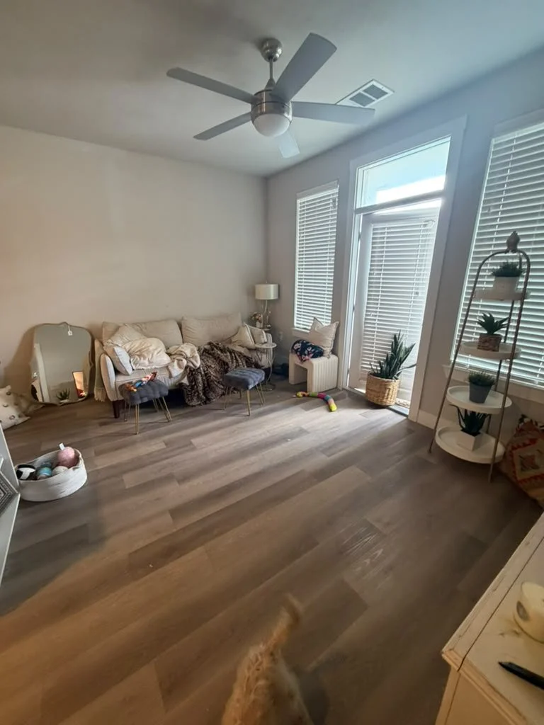 Before: living room floor and sofa covered in toys and clutter in an Austin apartment