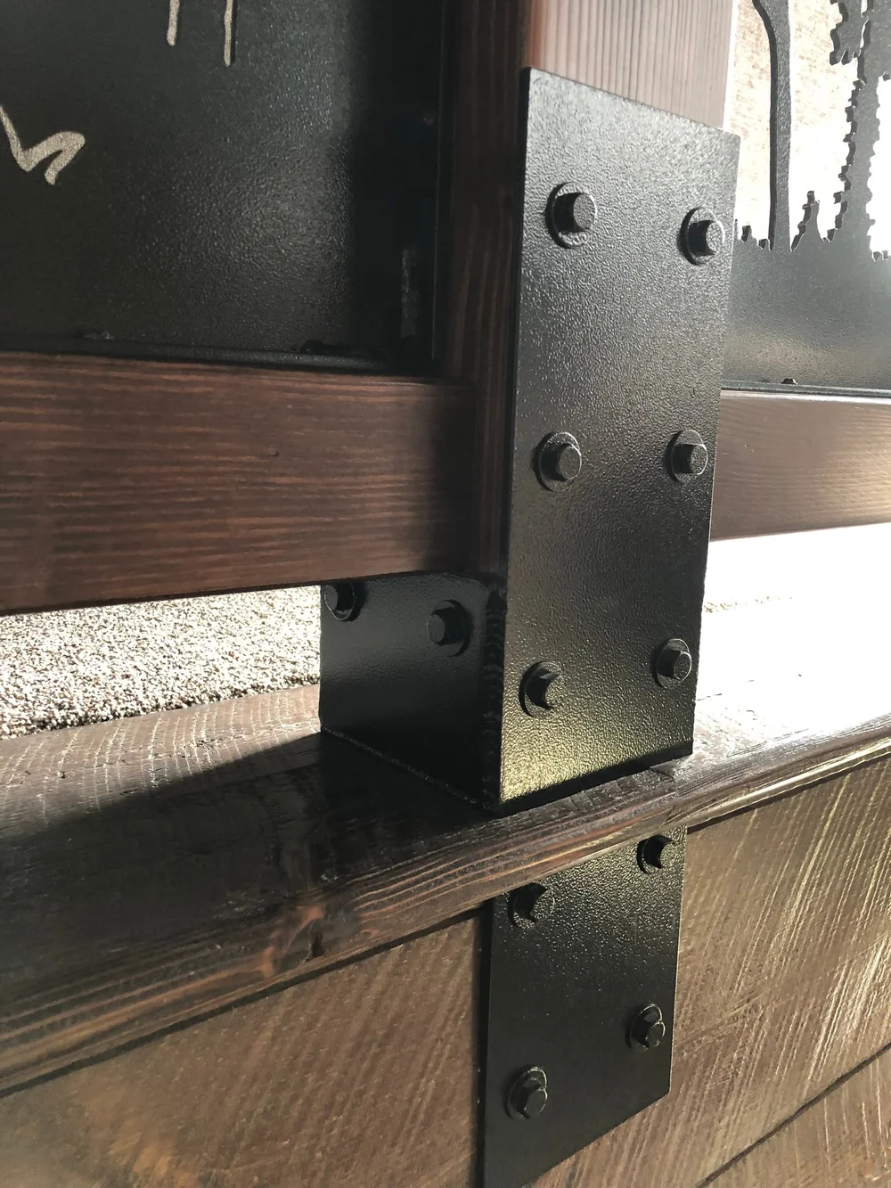 Bolted blackened-steel knife plate and post wrap on timber