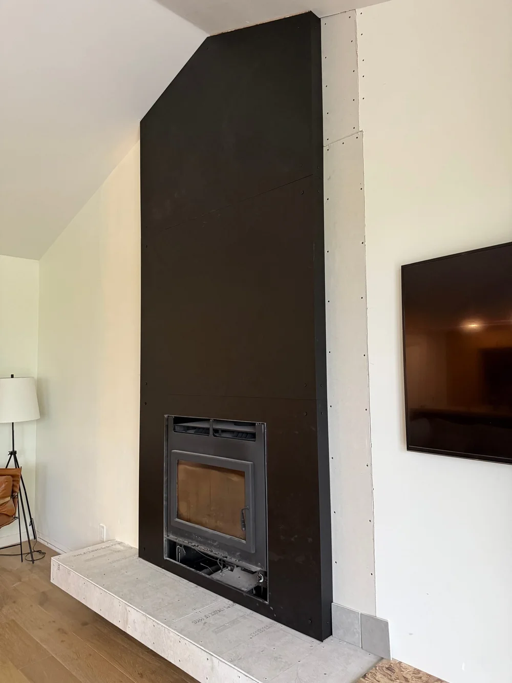 Floor-to-ceiling blackened-steel fireplace surround