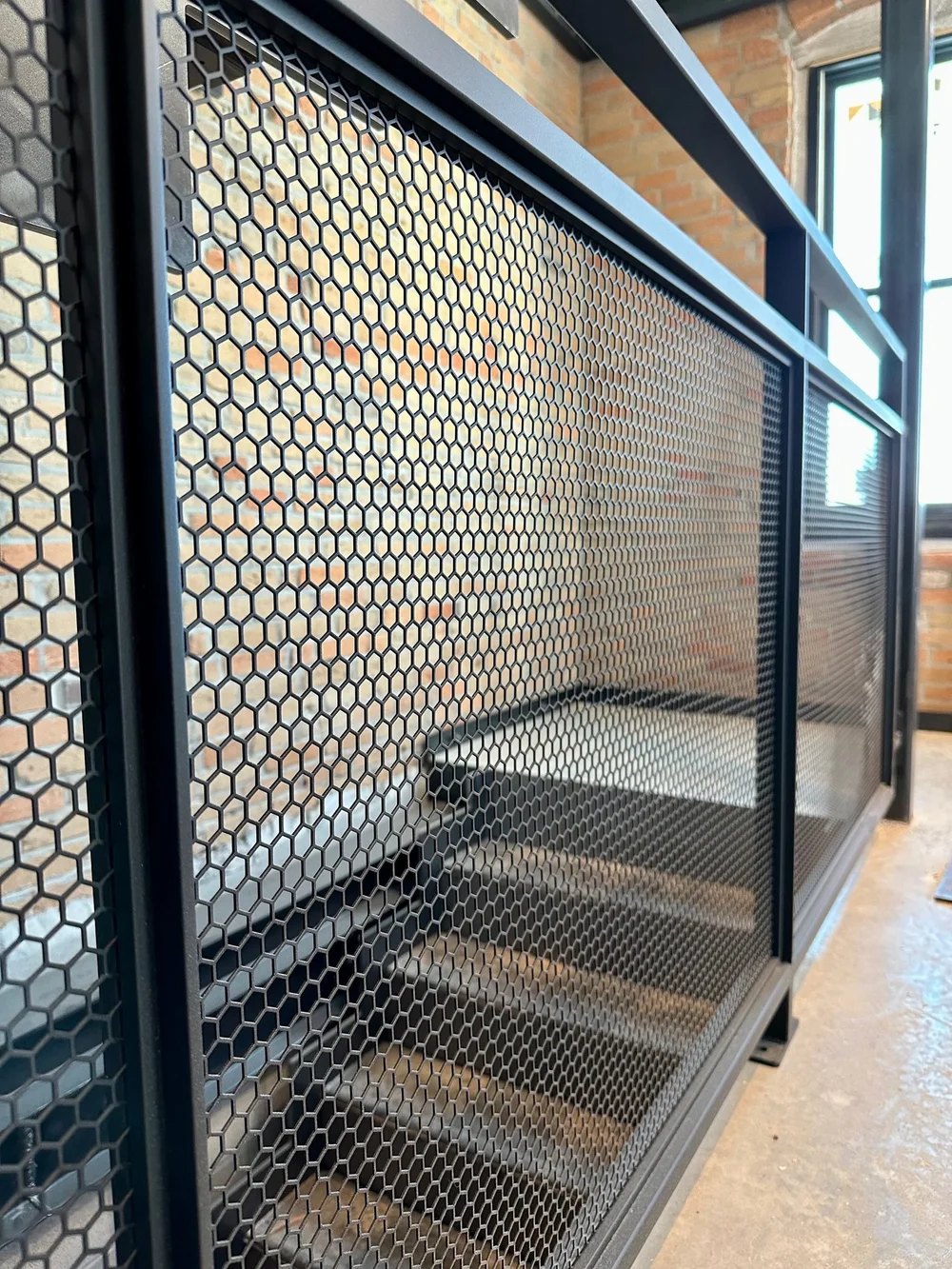 Hex-mesh steel guard on an open stair