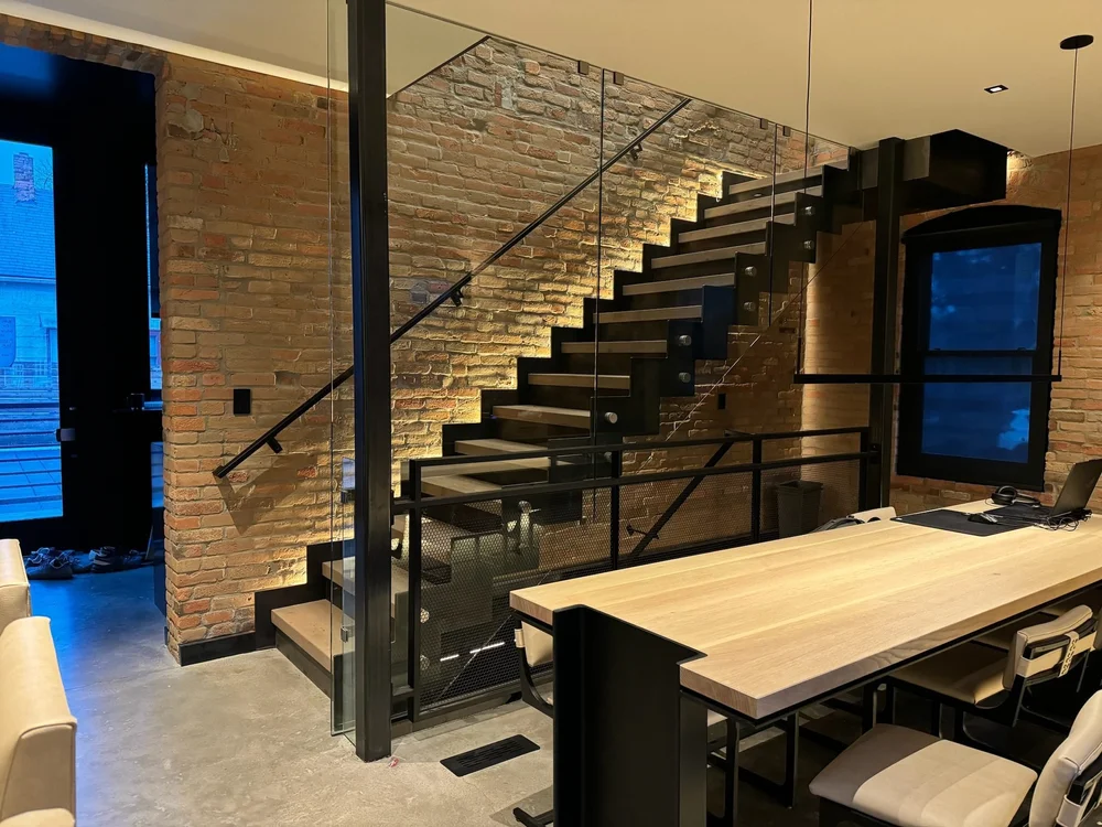 Open-riser steel stair against a brick wall