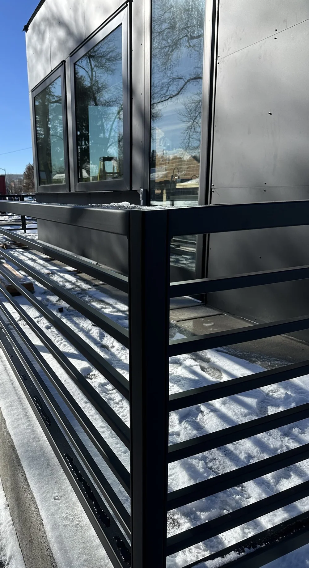Horizontal-bar steel railing on a black modern exterior