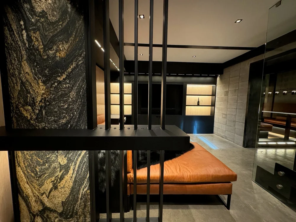 Vertical steel-fin screen beside a book-matched stone slab