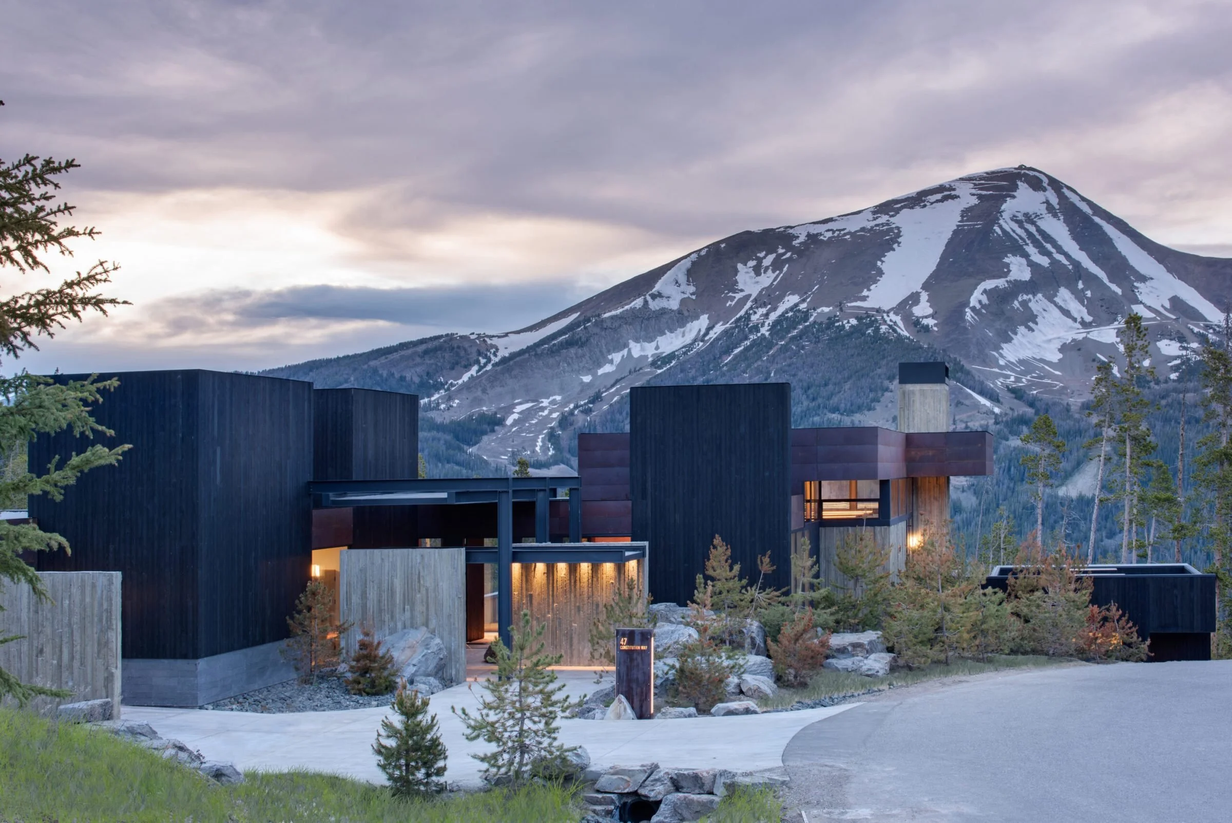 Modern black-clad mountain home at dusk