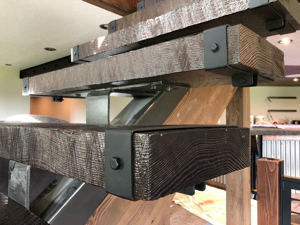 Blackened-steel wraps on heavy timber stair treads