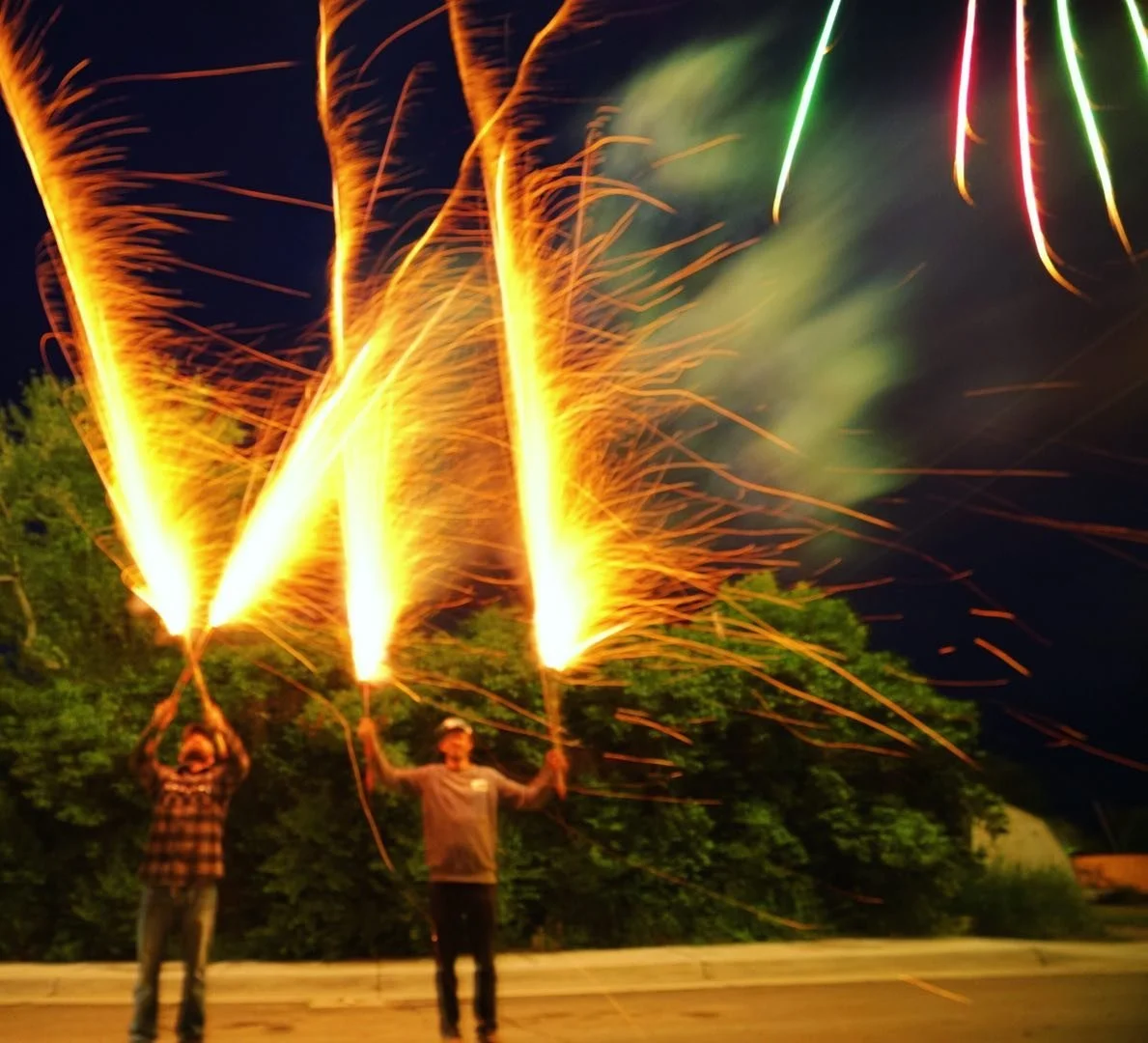 Friends beneath colorful fireworks in Ten Sleep, Wyoming