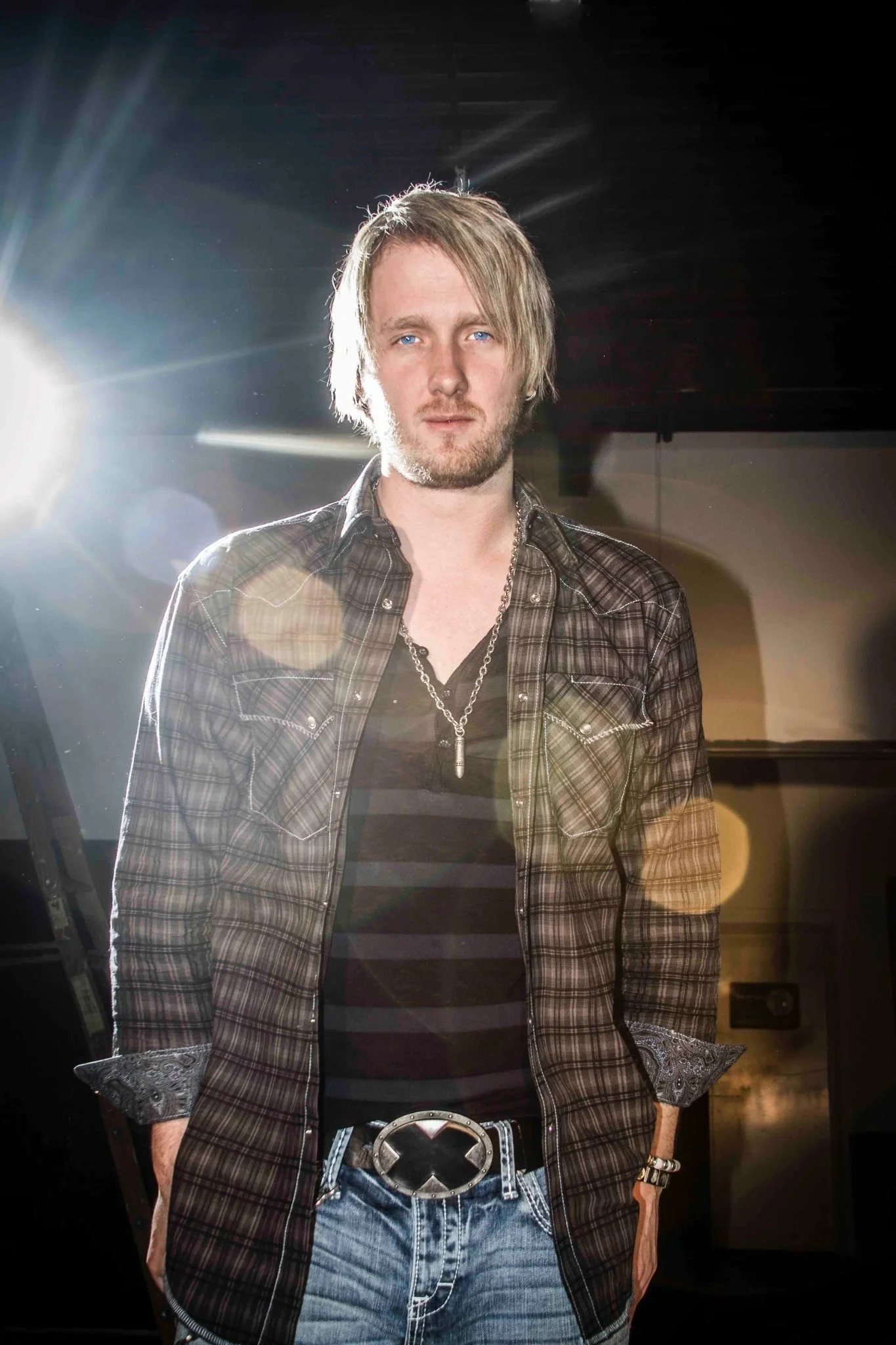 Portrait of a man in a plaid shirt with dramatic backlighting